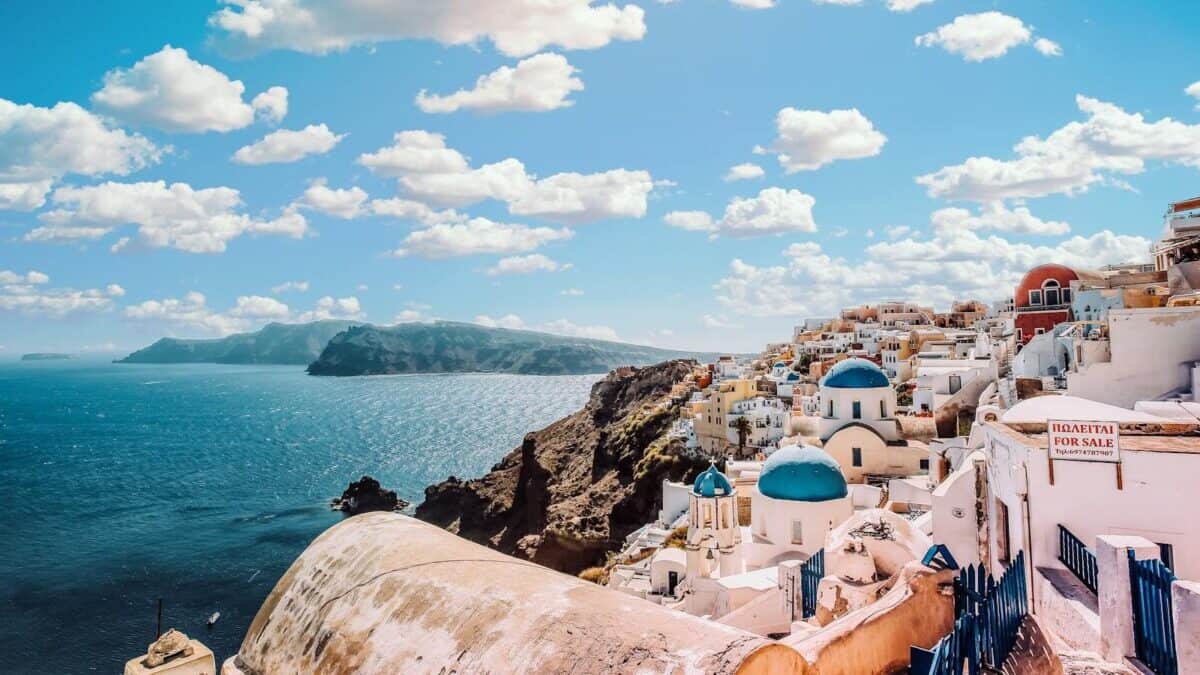 Captivating view of Santorini's famous blue-domed buildings under a vibrant sky.