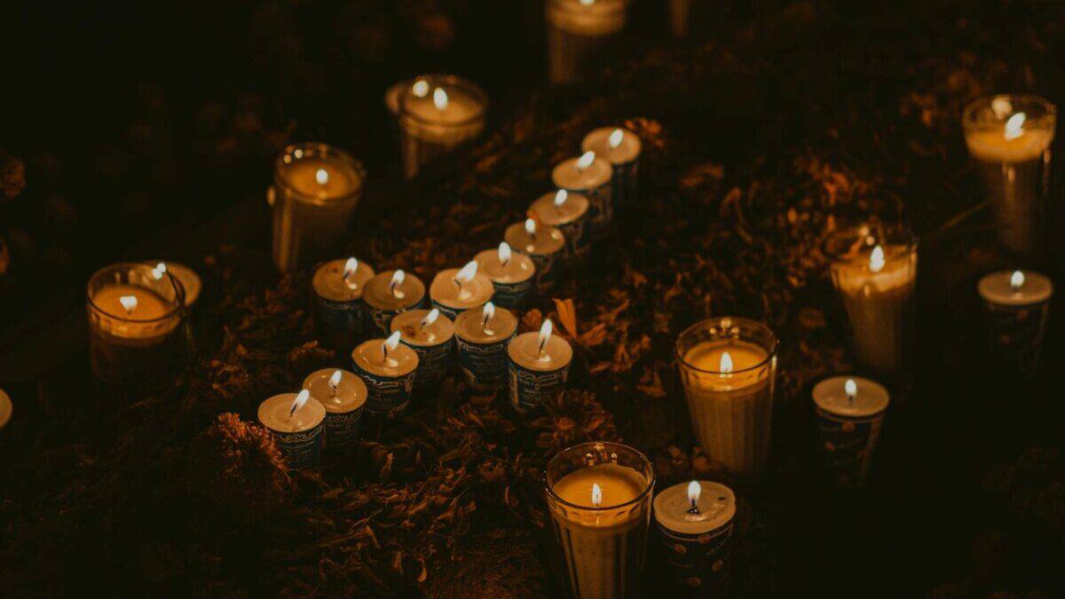Candlelit scene in Oaxaca cemetery, capturing the serene night ambiance.