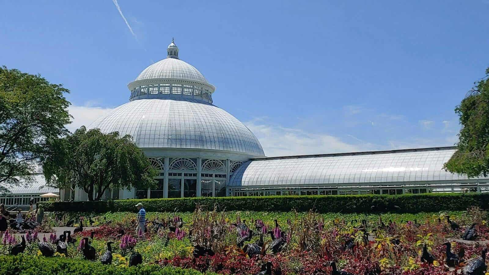 New York Botanical Garden | a large white building surrounded by trees and flowers