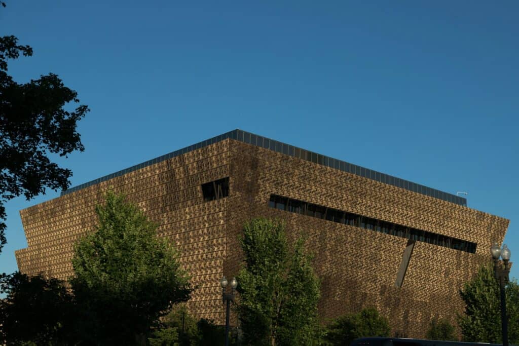 National Museum of African American History & Culture | a large building with a lot of windows and trees in front of it