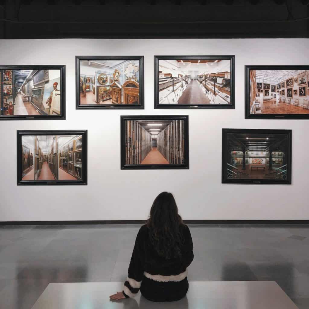 woman in a museum she is wearing black long sleeve shirt sitting on floor