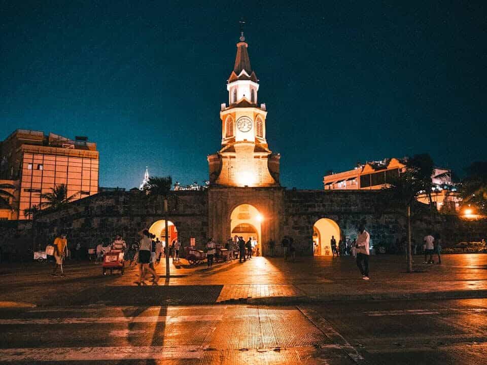 Cartagena, Colombia | a clock tower lit up at night in a city